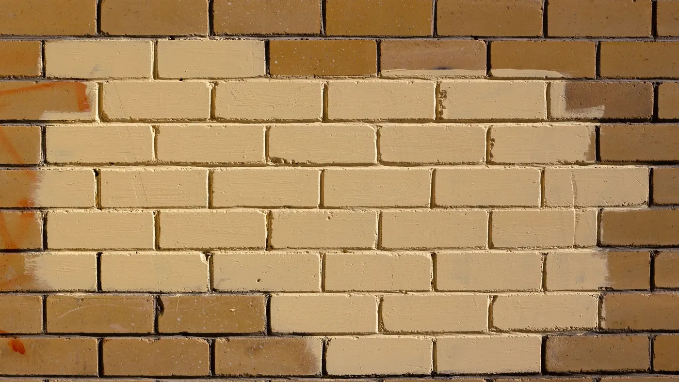 A painted brick wall in a warm ochre colour