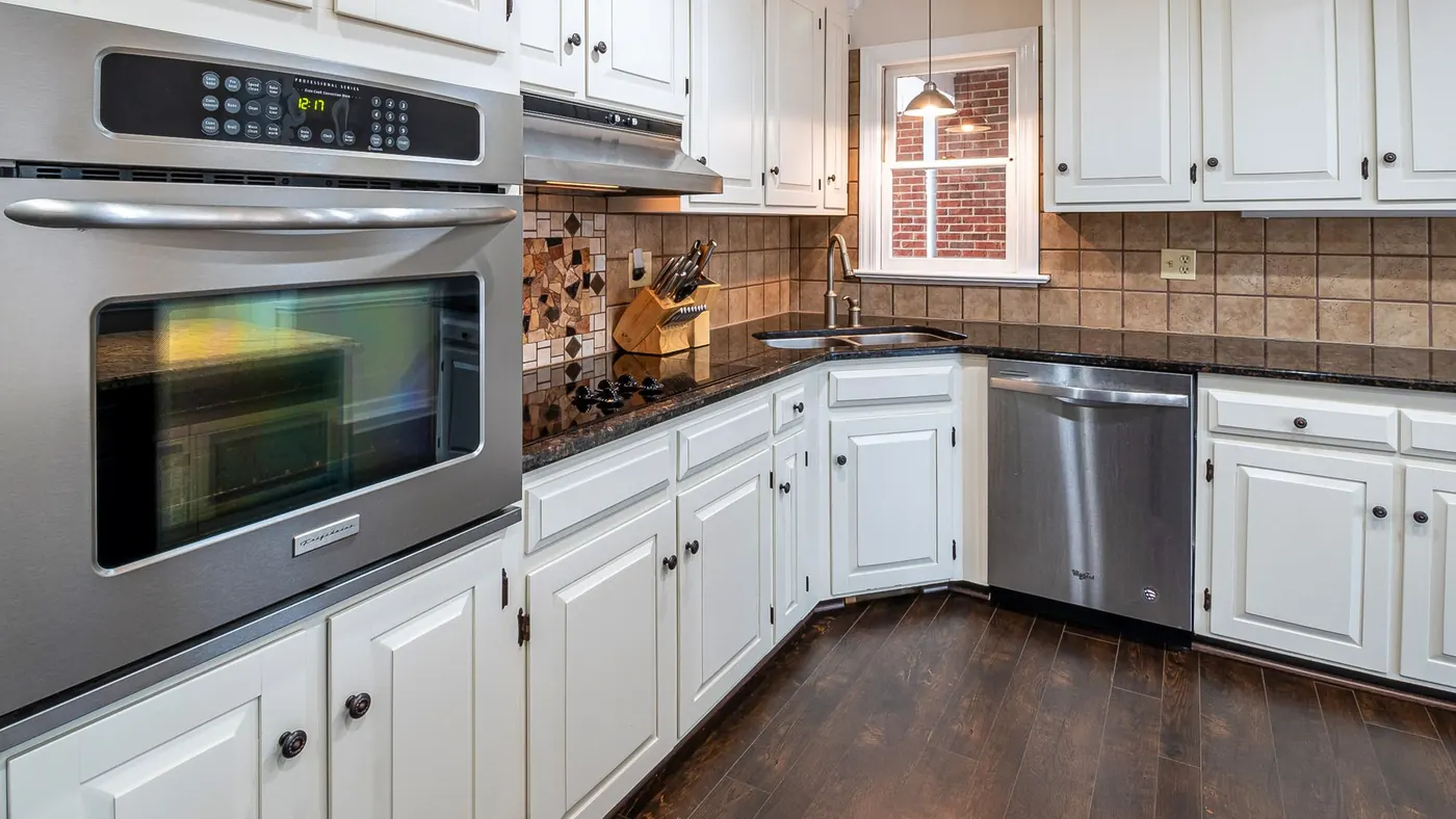 A kitchen with white raised-panel cabinet doors and steel appliances