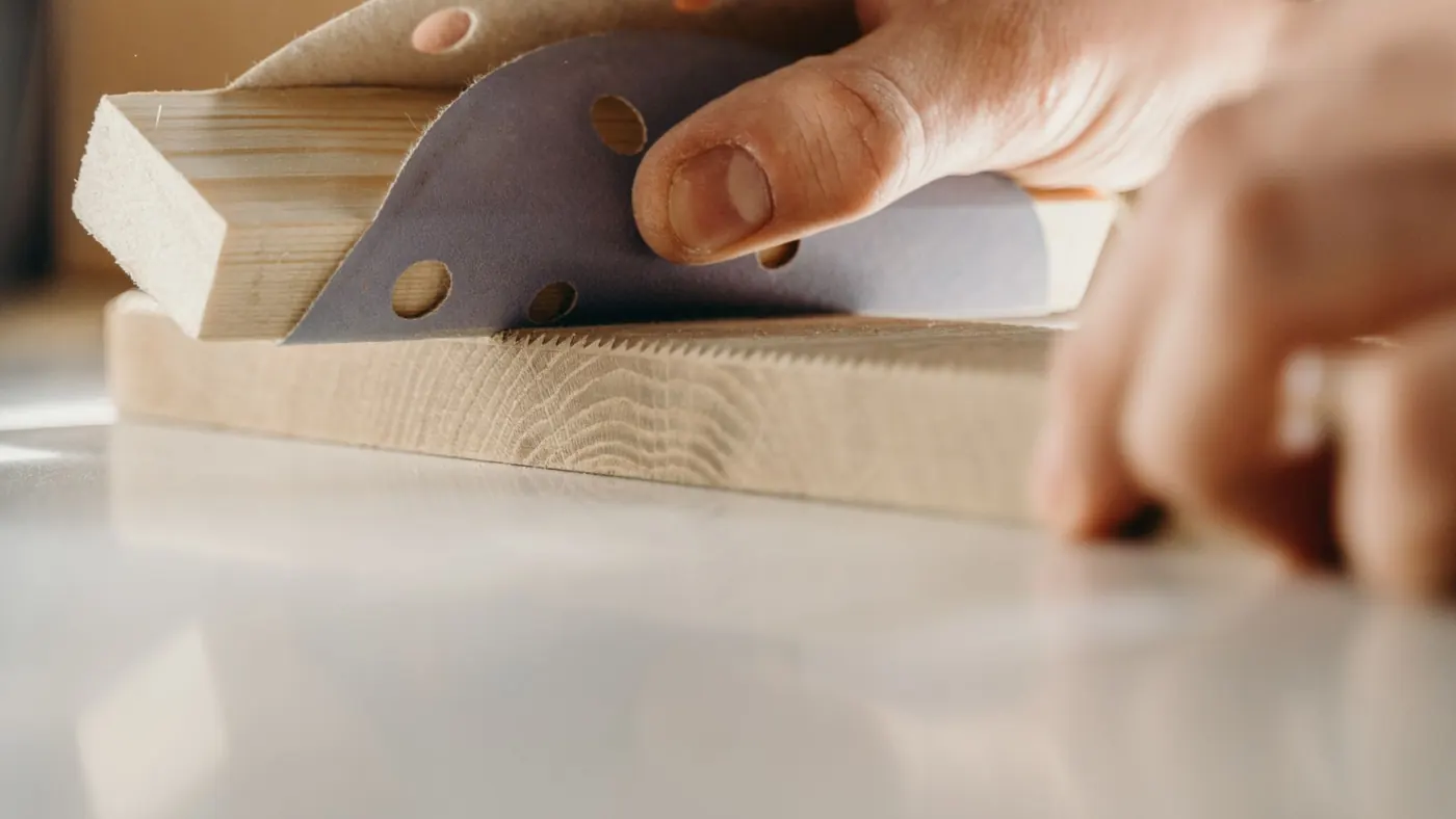 Hand sanding a timber edge smooth before the first coat