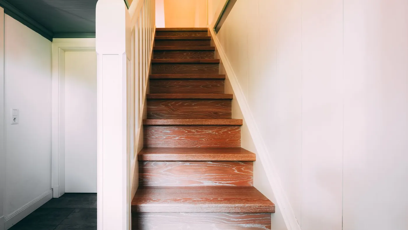 A varnished timber staircase turning up to a landing