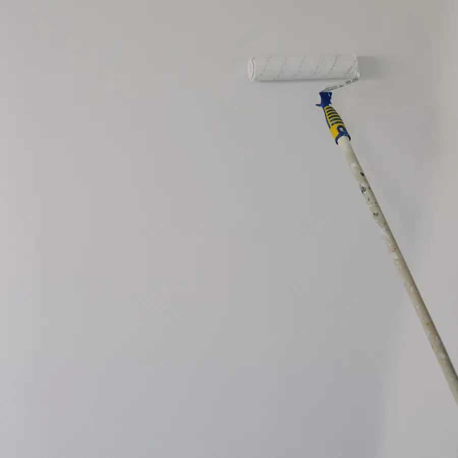Extension pole roller finishing a tall white wall