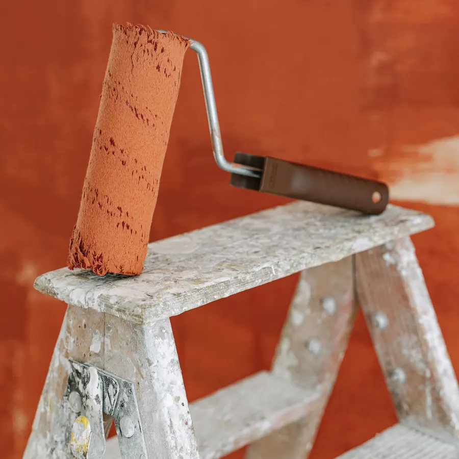 Terracotta emulsion on a wall with a wooden stepladder in front