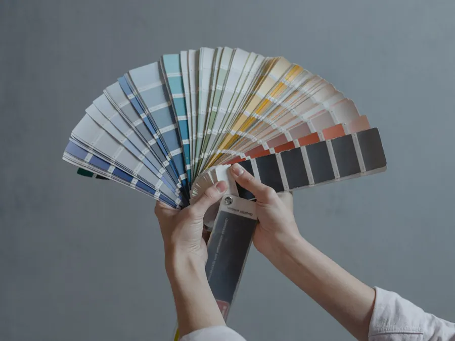 Colour swatches held up against a wall before the first coat